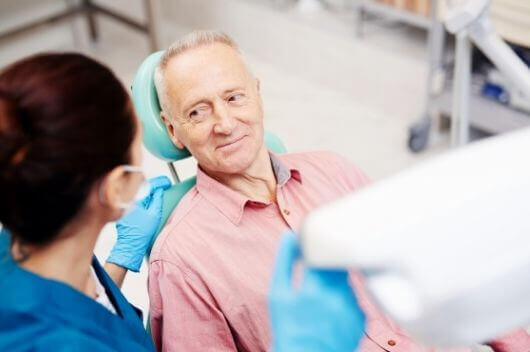 An older man sat at the dentist