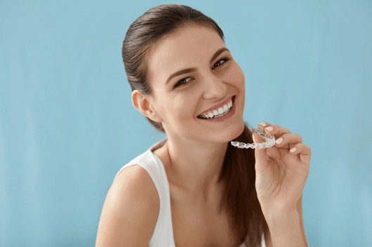 Brunette woman holding an invisible retainer