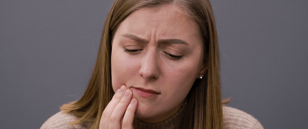 woman holding her mouth with toothache